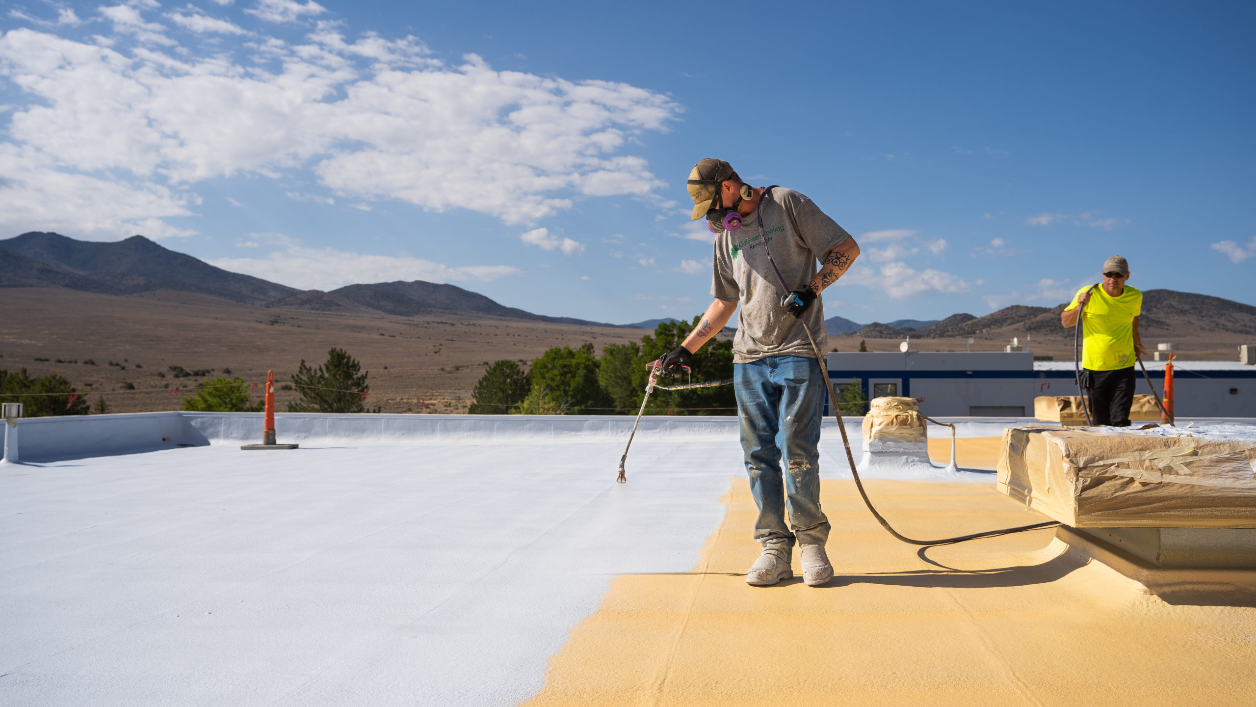 Spray foam and roof coating system being applied